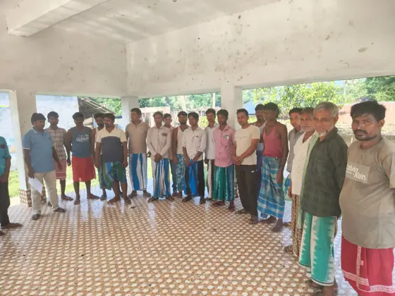 Workers standing in a row in an open hall.