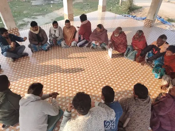 Workers sitting in a circle on a patterned floor.
