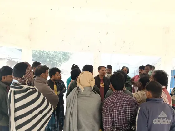 Workers gathered closely in a hall.